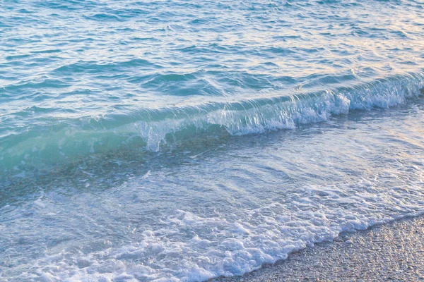 Sandy ve çakıl plaj üzerinde çalışan deniz dalgası