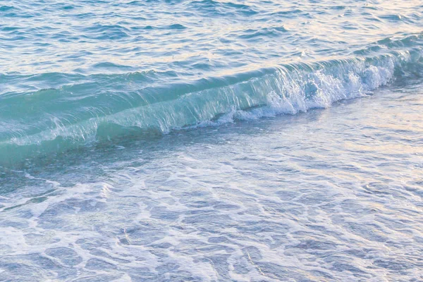 Sandy ve çakıl plaj üzerinde çalışan deniz dalgası