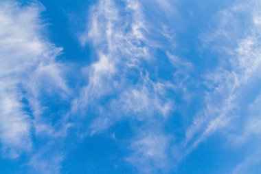 Beyaz tüylü bulutların üstünde yaz mavi gökyüzünde