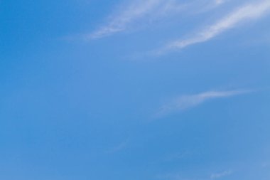 Beyaz tüylü bulutların üstünde yaz mavi gökyüzünde