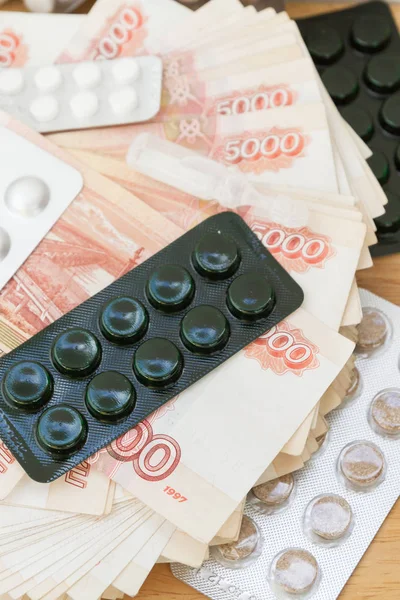 大量俄罗斯货币的药丸和毒品躺在桌子上 — 图库照片