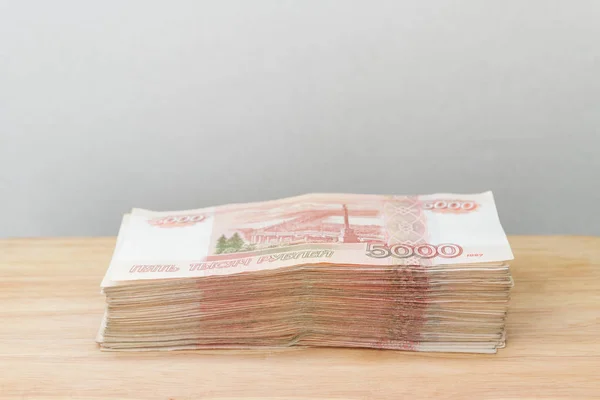 一大堆俄罗斯钞票5000卢布躺在一张木桌上 — 图库照片
