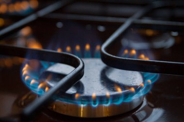 Turuncu ve mavi ateş üzerinde yanan gaz sobası