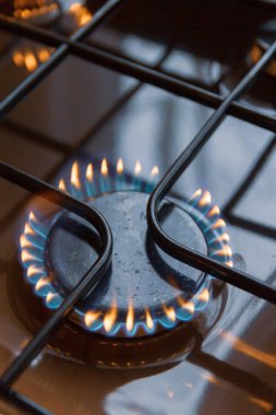 Turuncu ve mavi ateş üzerinde yanan gaz sobası
