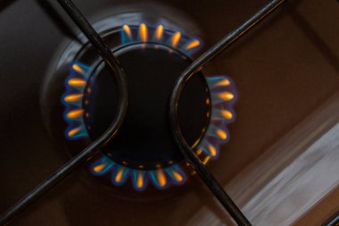 Turuncu ve mavi ateş üzerinde yanan gaz sobası