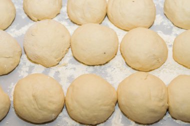 Un içinde haddelenmiş tablo çiğ hamur topları içine haddelenmiş açıktır