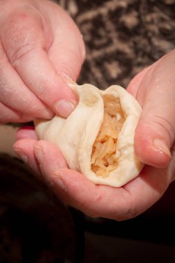 Yaşlı bir kadın evinde lahana ile pasta pişirme