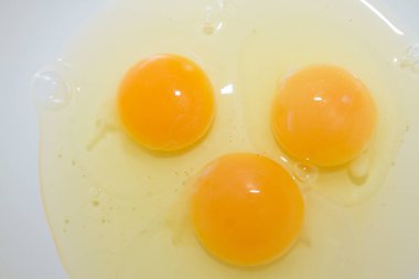 Üç kırık tavuk yumurta bir beyaz kase karıştırma