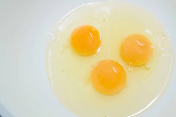 Три разбитых куриных яйца в белой миске — стоковое фото
