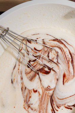 Erimiş soğutmalı bitter çikolata ile dövülmüş yumurta karıştırılır ve