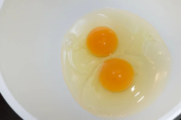 Due uova di pollo rotte in una ciotola bianca — Foto Stock