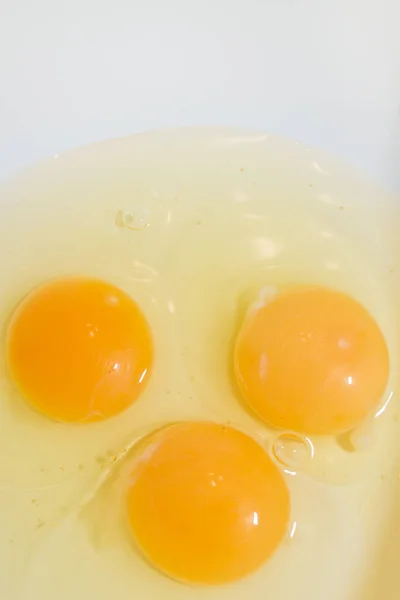 Три разбитых куриных яйца в белой миске — стоковое фото
