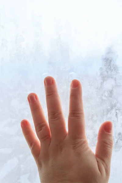 Hand auf gefrorenem Winterfenster mit Mustern — Stockfoto