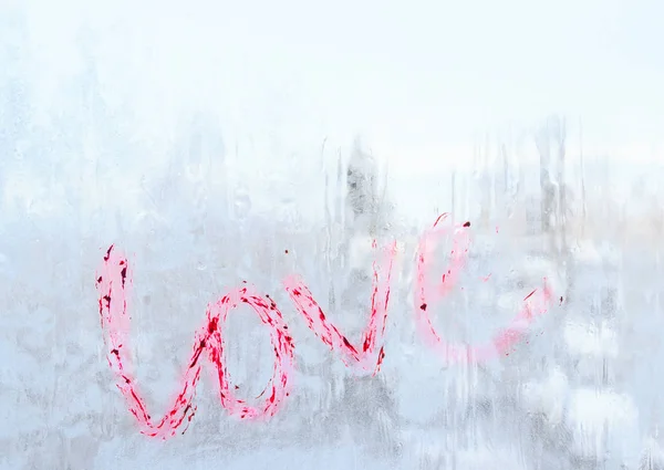 The inscription love written lipstick on a frozen winter window — Stock Photo, Image