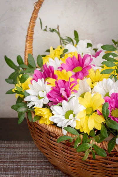 Beautiful colorful chrysanthemum flowers in a wicker basket — Stock Photo, Image