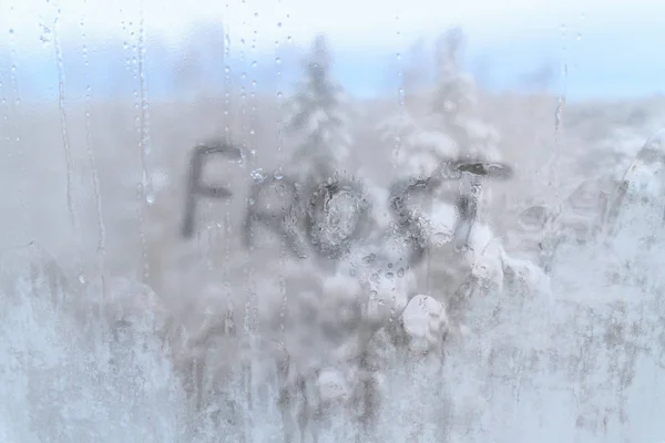 Inscription frost on frozen cold of the winter window — Stock Photo, Image