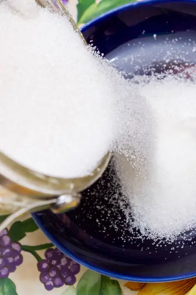 La sabbia bianca dello zucchero è versata in un piattino per la cottura — Foto Stock