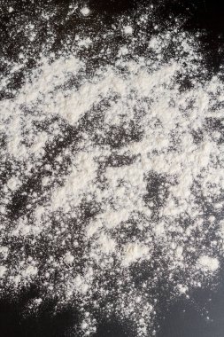 Kurabiye pişirmeden önce siyah bir masaya beyaz un dökülür.