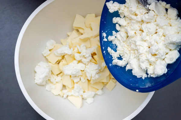 Ajouter du fromage cottage à des morceaux de beurre dans un bol pour faire c — Photo