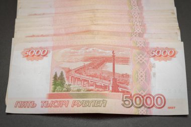 Siyah bir arka plan üzerinde yatan beş bin banknot