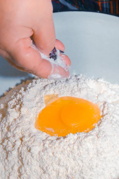 Garam ditambahkan ke adonan untuk pangsit dalam mangkuk di atas telur — Stok Foto