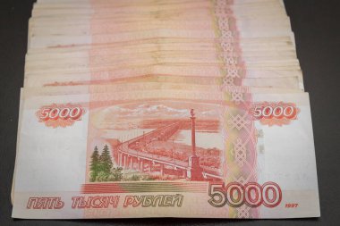 Siyah bir arka plan üzerinde yatan beş bin banknot