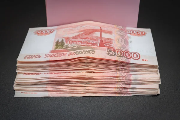 Большая пачка русских денег рядом с подарочной коробкой — стоковое фото