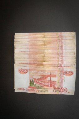 Siyah bir arka plan üzerinde yatan beş bin banknot