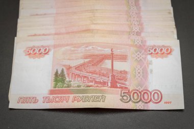 Siyah bir arka plan üzerinde yatan beş bin banknot