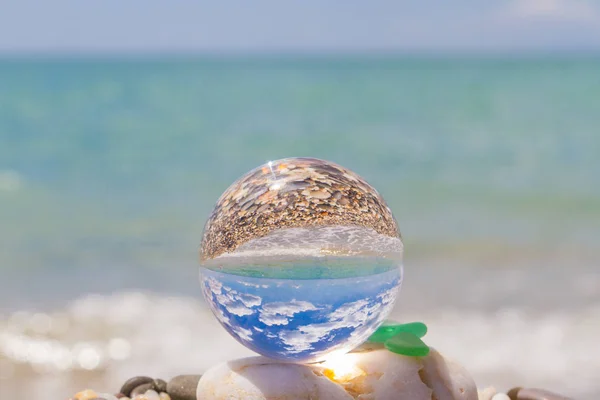 Bola redonda de vidro na praia reflete o mar no verão — Fotografia de Stock