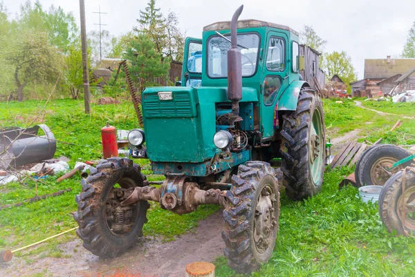 Starý traktor ve vesnici na začátku jara — Stock fotografie