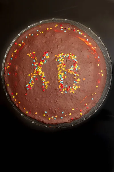 Шоколадный торт на Пасху с надписью HV с цветным spr — стоковое фото