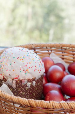 Bir hasır sepette boyalı tavuk yumurtası ile Paskalya bahar kek