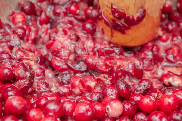 Aplastar las bayas rojas de arándano con un rodillo de madera — Foto de Stock