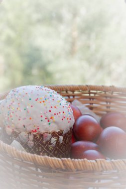 Bir hasır sepette boyalı tavuk yumurtası ile Paskalya bahar kek