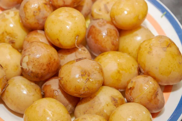 Patatas jóvenes hervidas en uniforme acostadas en un plato — Foto de Stock
