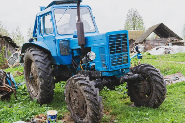 Vieux tracteur dans le village au début du printemps — Photo