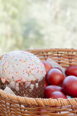 Bir hasır sepette boyalı tavuk yumurtası ile Paskalya bahar kek