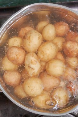 Yeni patatesler derilerinde bir tencerede kaynatın