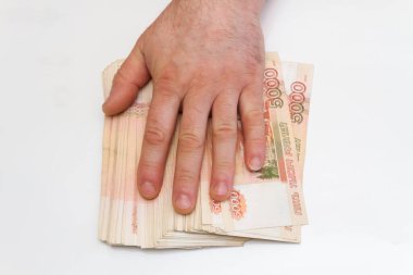 Bir adamın eli beş bin rublelik banknotları sayar ve taşır.