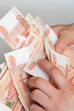 Beş bin rublelik Rus banknotlarıyla erkeklerin elinde büyük miktarda para var.