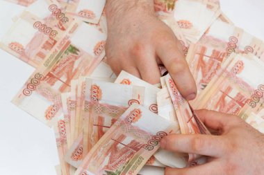 Beş bin rublelik Rus banknotlarıyla erkeklerin elinde büyük miktarda para var.