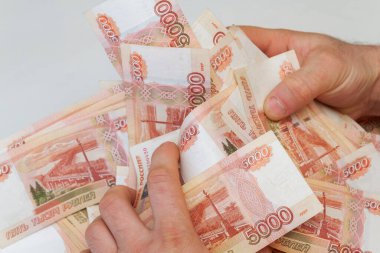 Beş bin rublelik Rus banknotlarıyla erkeklerin elinde büyük miktarda para var.
