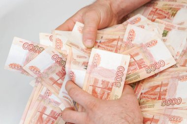 Beş bin rublelik Rus banknotlarıyla erkeklerin elinde büyük miktarda para var.
