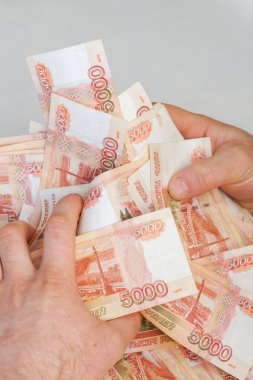 Beş bin rublelik Rus banknotlarıyla erkeklerin elinde büyük miktarda para var.
