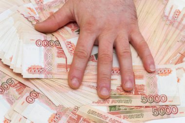 Bir adamın eli beş bin rublelik banknotları sayar ve taşır.