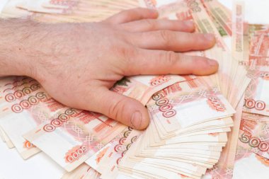 Bir adamın eli beş bin rublelik banknotları sayar ve taşır.