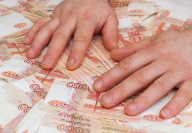 Bir adamın eli beş bin rublelik banknotları sayar ve taşır.