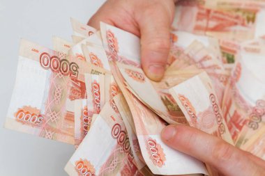 Beş bin rublelik Rus banknotlarıyla erkeklerin elinde büyük miktarda para var.