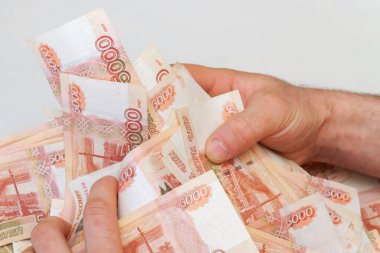 Beş bin rublelik Rus banknotlarıyla erkeklerin elinde büyük miktarda para var.